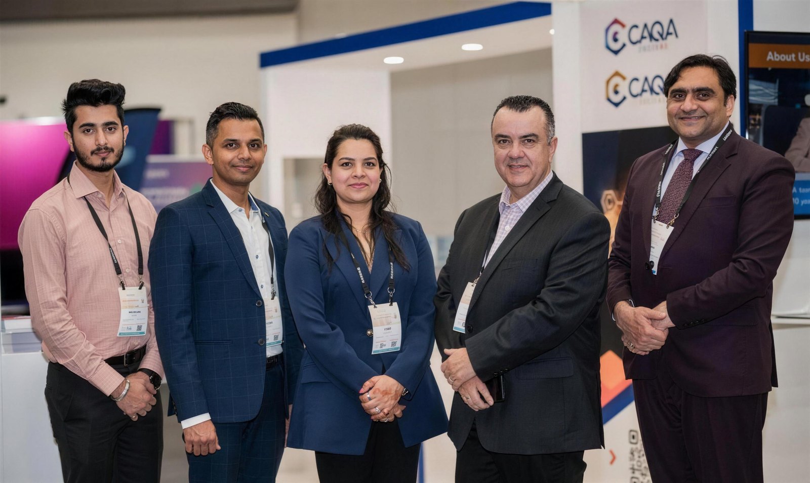 The CAQA team poses at a conference booth, showcasing compliance services.