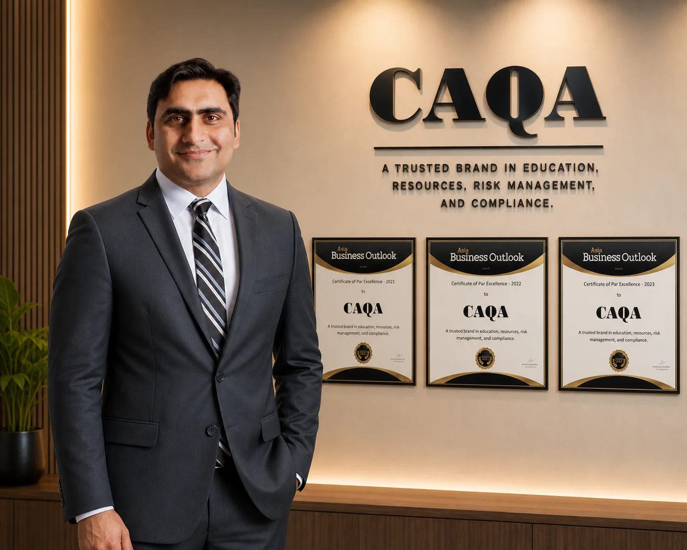 Sukh Sandhu at the CAQA office beside the Asia Business Outlook certificates