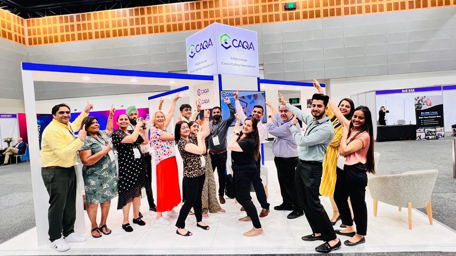 The CAQA Systems team at a national conference booth discussing compliance services.