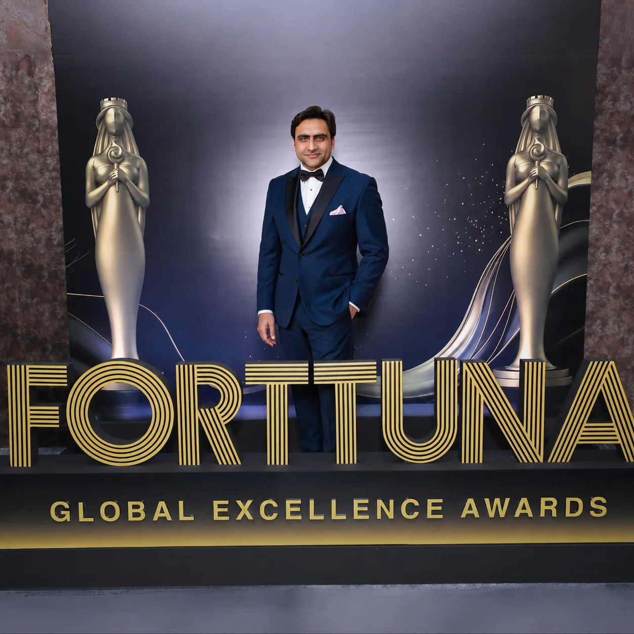 Sukh Sandhu behind the Forttuna Global Excellence Awards sign