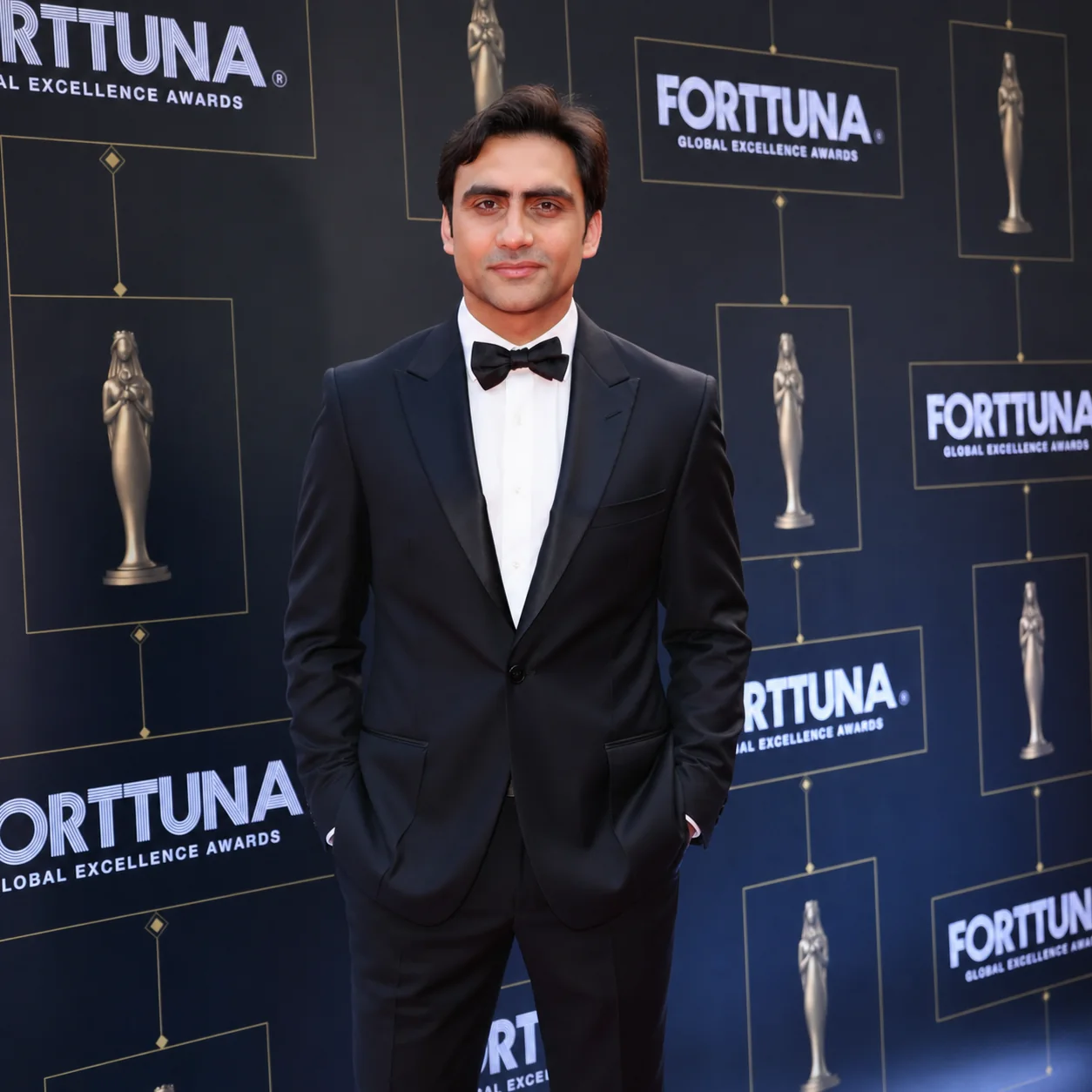 Sukh Sandhu poses in a tuxedo at the Forttuna Global Excellence Awards event, receiving recognition for compliance services.