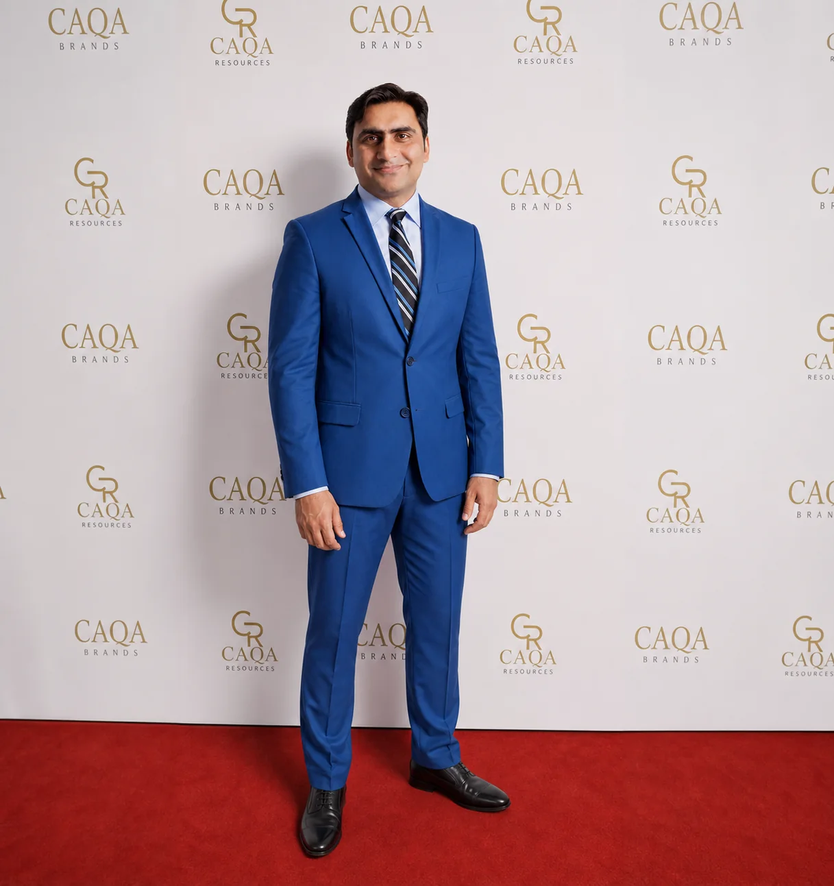 Sukh Sandhu poses on a red carpet at the CAQA Brands event as an ISO auditor.