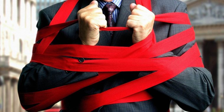 Bureaucracy | Sukh Sandhu A businessman struggles against red tape, representing the challenges of compliance and regulation in education.