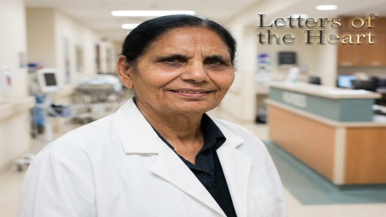 Female Doctor | Sukh Sandhu A female doctor in a white lab coat smiles in a healthcare setting, representing professional development and care.