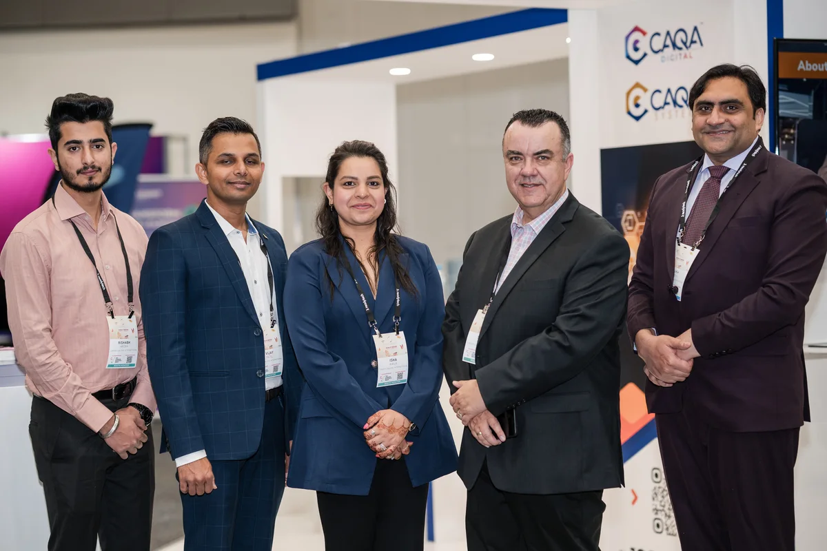 Five professionals pose at a conference, showcasing Sukh Sandhu's work in compliance.