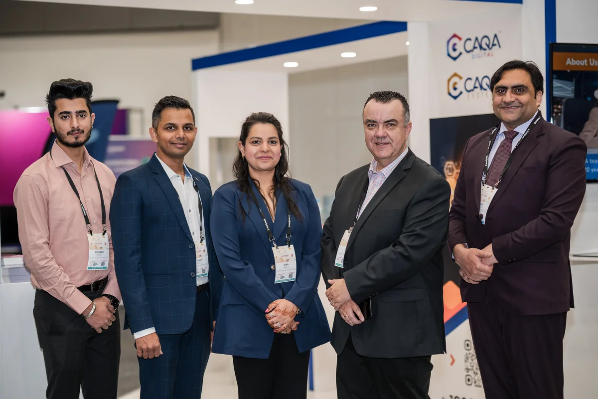 A team of professionals poses at a conference, showcasing Sukh Sandhu's expertise in compliance services.