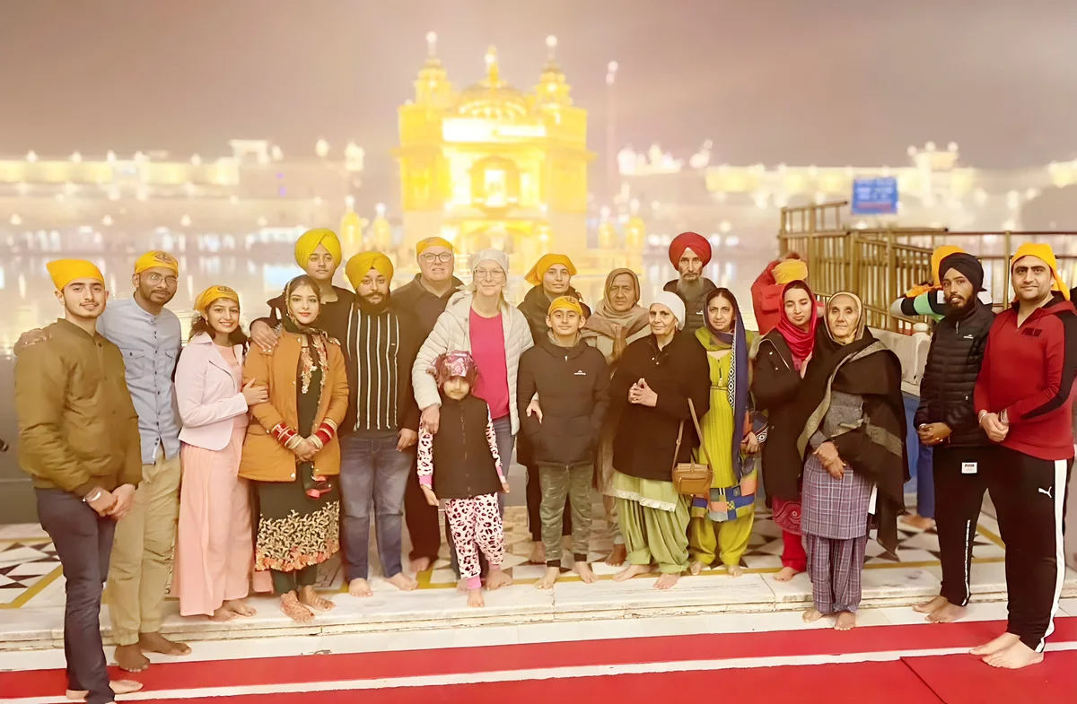 A large group including Sukh Sandhu poses at the Golden Temple in Amritsar, India.