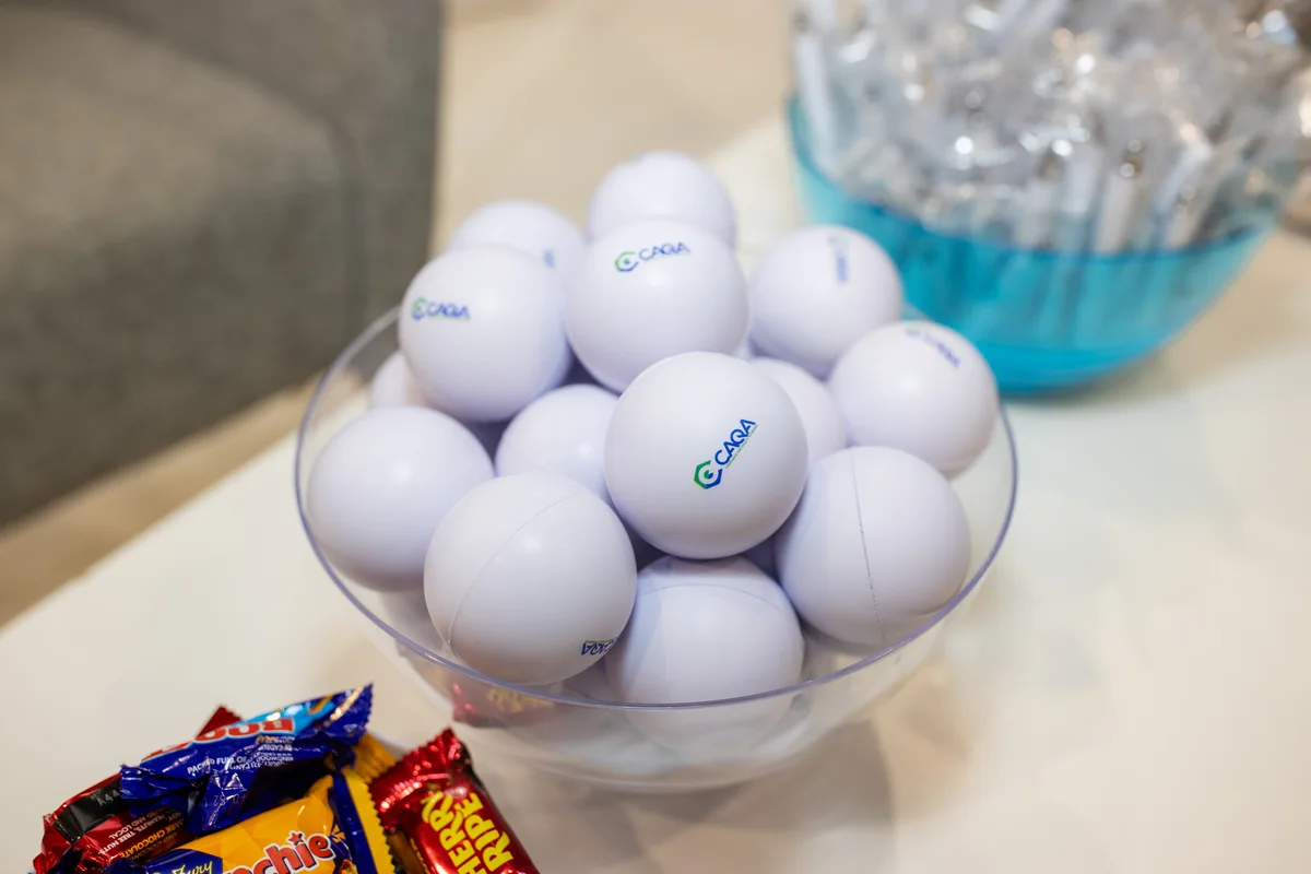 A bowl of golf balls with logos sits beside candy, representing Sukh Sandhu's work in compliance.