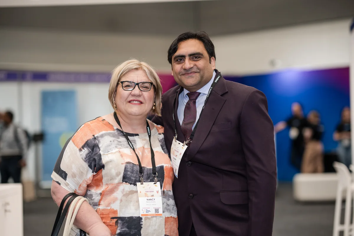 Sukh Sandhu and Nancy Pelligra smile during a conference, showcasing professional development.