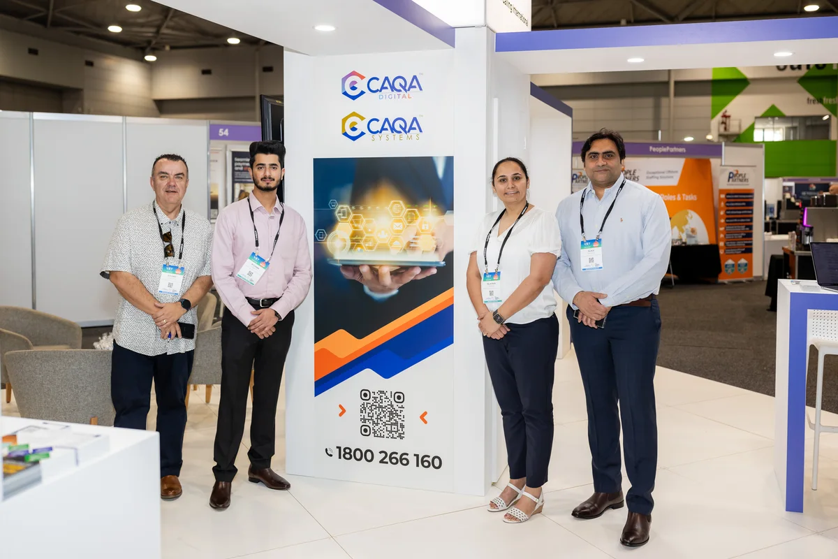 Employees represent CAQA Digital Systems at a trade show, demonstrating compliance services.