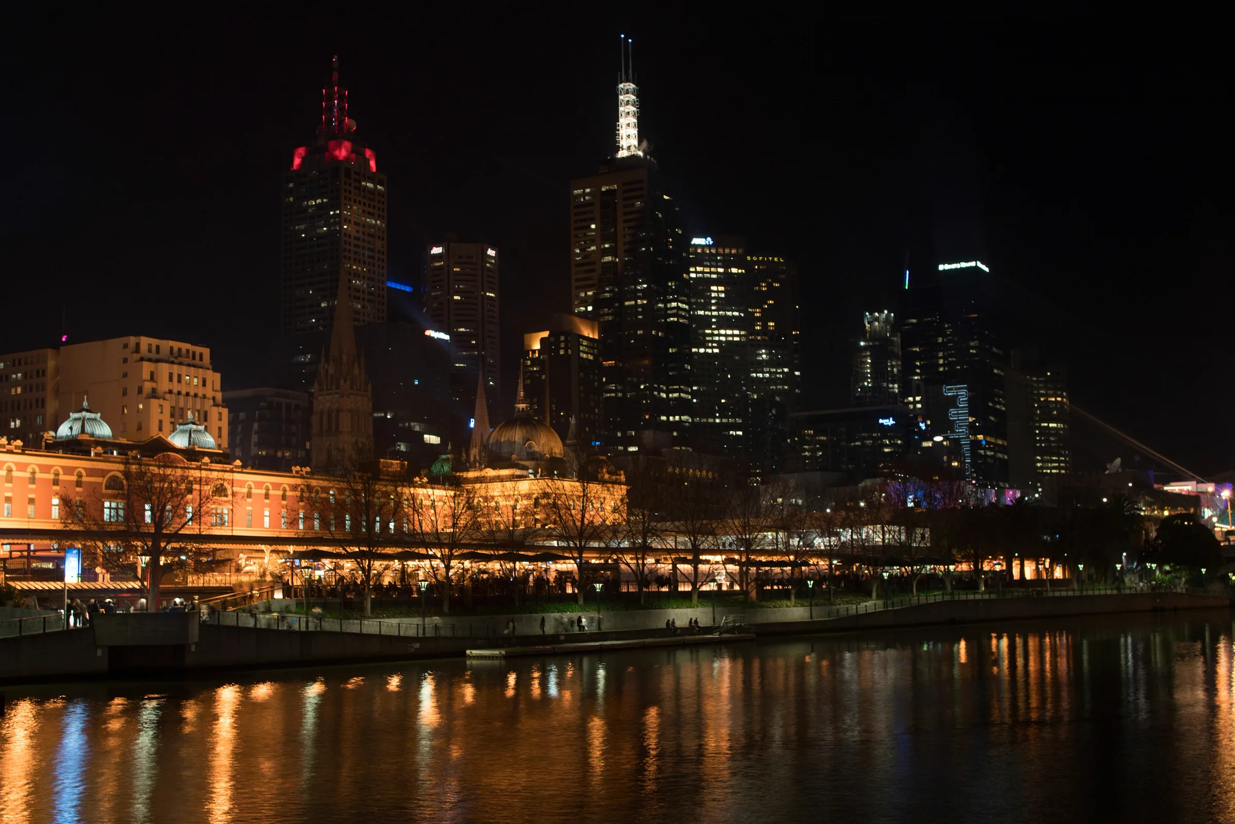 Melbourne's illuminated skyline reflects on the Yarra River at night.
